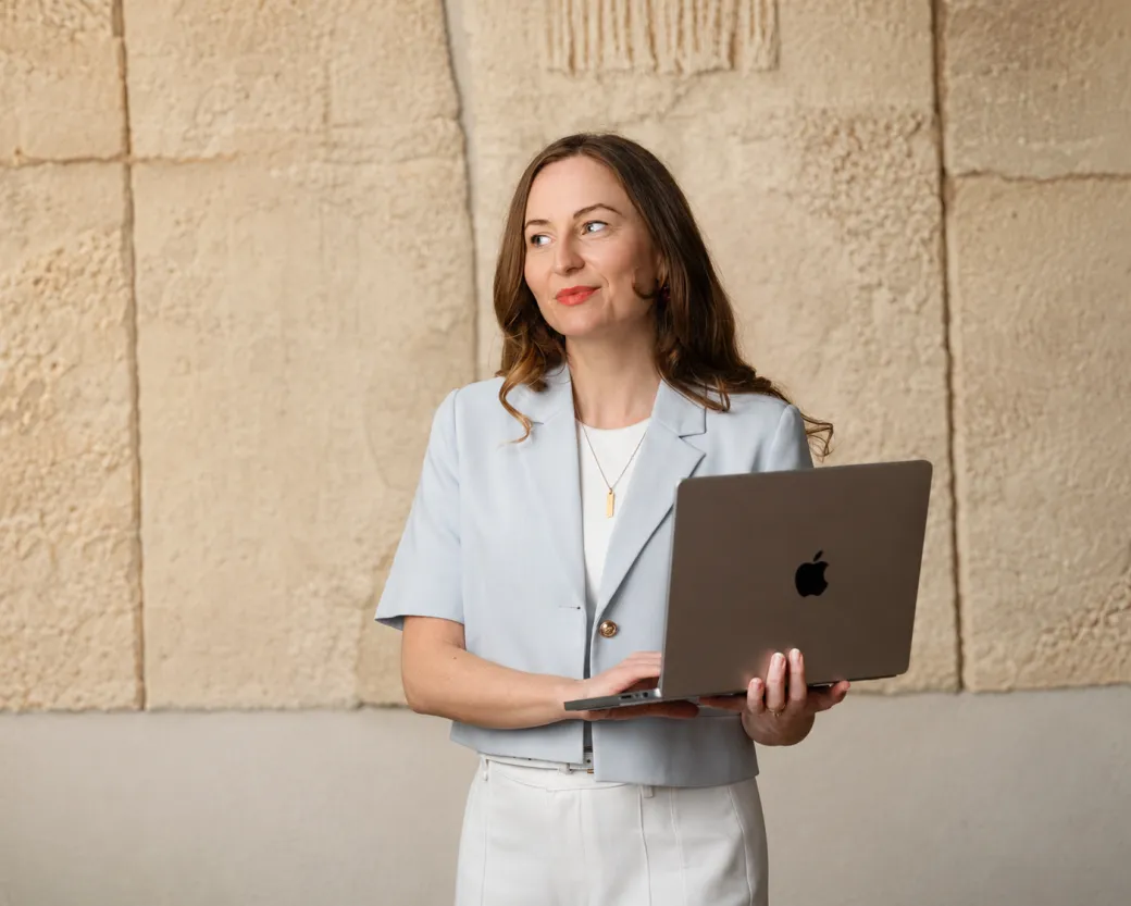 Lu, founder of Uplift Digital, standing with her laptop